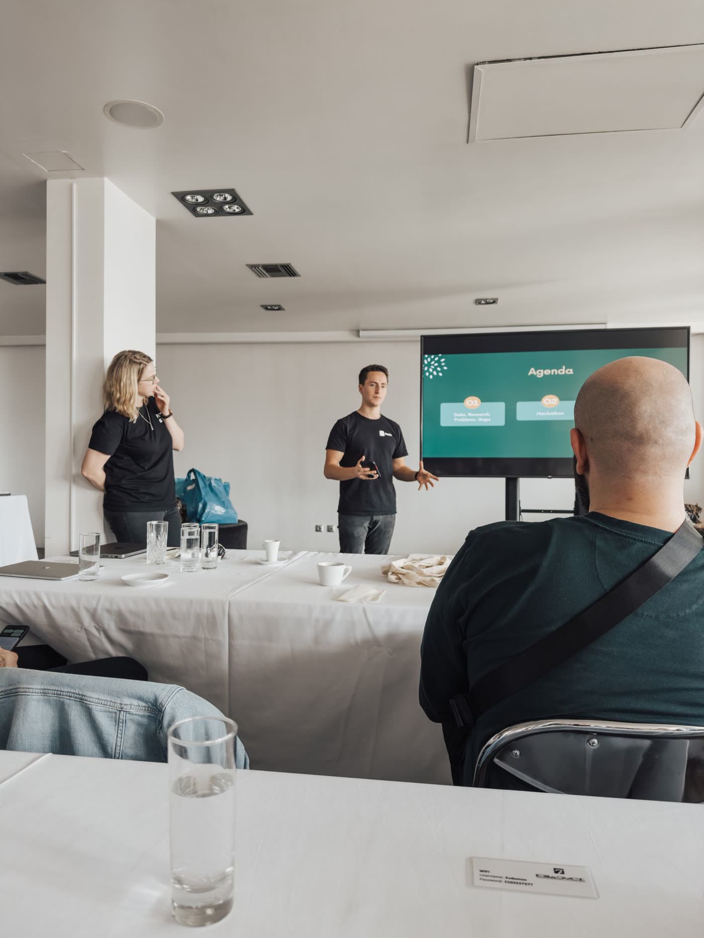 A working session: business owners watching a live software demo on screen.